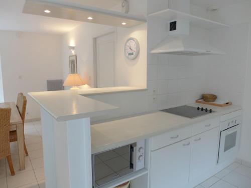 une cuisine blanche avec un comptoir et un évier dans l'établissement Villa Eden Club by Interhome, à Lacanau-Océan