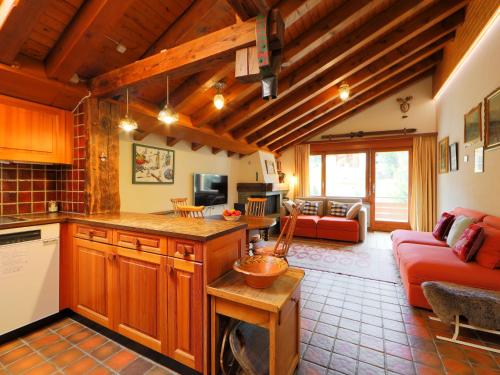 ツェルマットにあるApartment Haus Rollin by Interhomeのキッチン、リビングルーム(赤いソファ付)