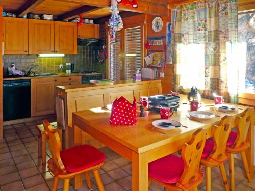 ジナルにあるChalet Lò Batcho by Interhomeのキッチン(木製テーブル、赤い椅子付)
