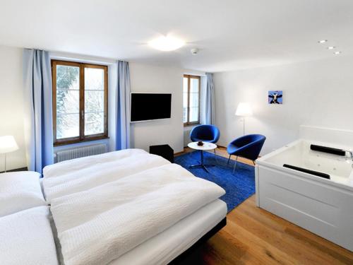 a bedroom with a bed and a desk and a tv at Apartment Sternen B by Interhome in Lenk