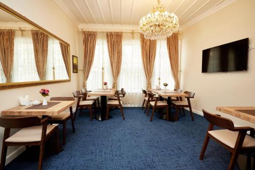 une salle à manger avec des tables et des chaises ainsi qu'un lustre dans l'établissement Mataraci Konak, à Istanbul