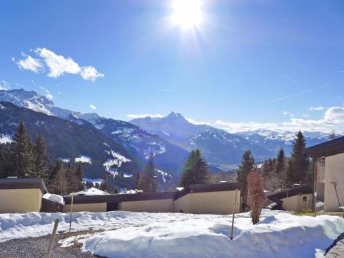 un patio cubierto de nieve con montañas al fondo en Apartment La Vire D'Aufalle 14 Inférieur by Interhome, en Arveyes