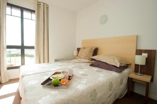 a tray of fruit on a bed in a bedroom at Résidence Goélia Belle Epoque in Mers-les-Bains