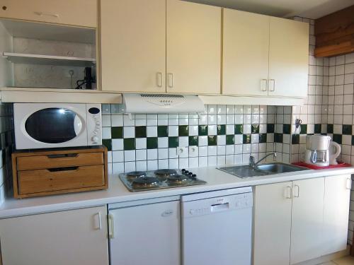 a kitchen with a microwave and a sink at Apartment L'Oisans by Interhome in Les Menuires