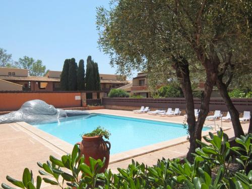 - une piscine dans une cour avec un arbre dans l'établissement Studio du Golf by Interhome, à Saint Cyprien Plage