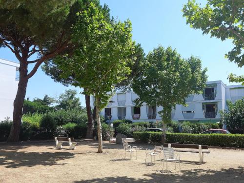 un parc avec des chaises et des arbres et un bâtiment dans l'établissement Apartment Marin'Land-2 by Interhome, à La Grande Motte