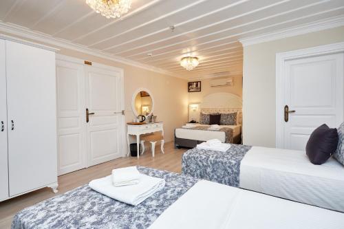 伊斯坦布尔玛塔拉奇考拉克酒店的一间酒店房间，里面有两张床和一张桌子。