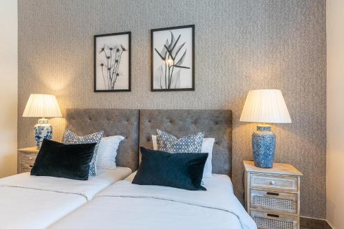 dwa łóżka w sypialni z trzema zdjęciami na ścianie w obiekcie Carregado House close to Lisbon w mieście Carregado