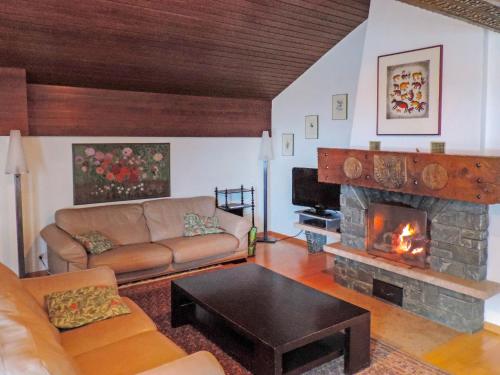 ein Wohnzimmer mit einem Sofa und einem Kamin in der Unterkunft Apartment Imperial-10 by Interhome in Zermatt