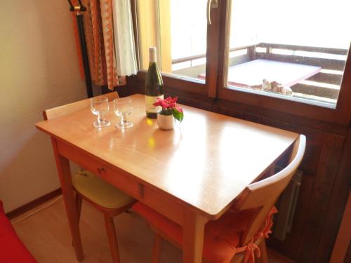 オヴロナにあるApartment Tourbillon A 27 by Interhomeの木製テーブル(グラス付)とワイン1本