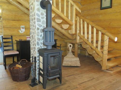a wood stove in a room with a staircase at Chalet Lazny by Interhome in Pohorsko