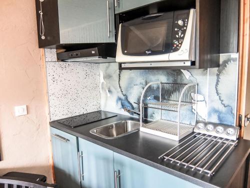 uma cozinha com um lavatório e um micro-ondas em Apartment Le Villaret-8 by Interhome em Les Menuires