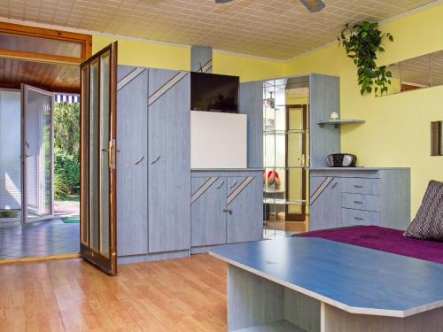 una cocina con armarios de madera y una mesa en una habitación en Holiday Home Azzurro by Interhome en Balatonmáriafürdő