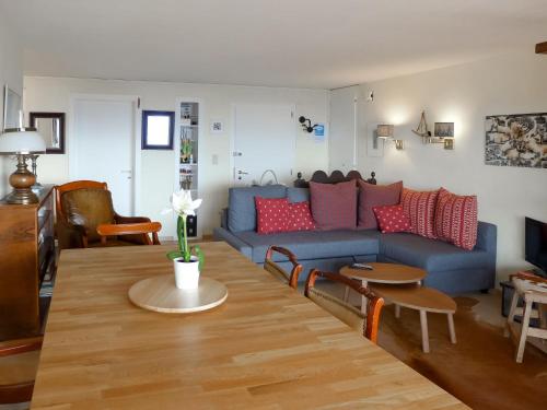 - un salon avec un canapé bleu et des oreillers rouges dans l'établissement Apartment Schuss 23 by Interhome, à Villars-sur-Ollon
