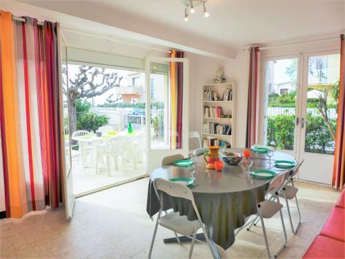 une salle à manger avec une table avec des chaises et une chambre avec vue dans l'établissement Apartment Les Hirondelles by Interhome, à Narbonne-Plage