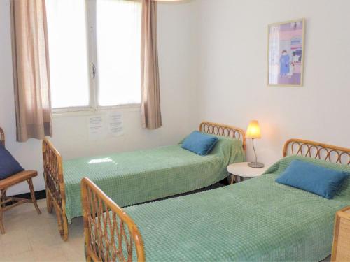 une chambre avec deux lits et une fenêtre dans l'établissement Apartment Les Hirondelles by Interhome, à Narbonne-Plage