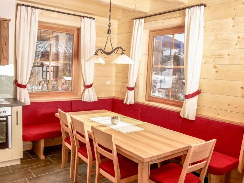 ハイリゲンブルートにあるChalet Glockner by Interhomeのダイニングルーム(木製テーブル、赤い椅子付)
