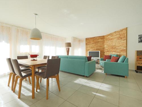 ein Wohnzimmer mit einem Tisch und einem blauen Sofa in der Unterkunft Apartment Susanna by Interhome in Zermatt