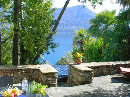 ブリッサーゴにあるHoliday Home Garuda by Interhomeの湖の景色を望む石壁