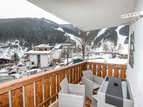 einen Balkon mit einem Tisch und Stühlen sowie einem schneebedeckten Berg in der Unterkunft Apartment Holiday-5 by Interhome in Zell am See