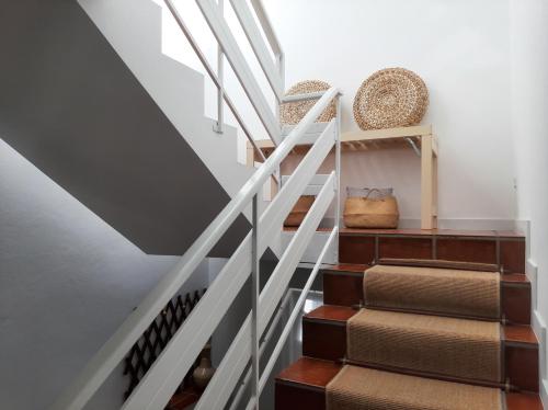 a stairwell with a white rail and wooden stairs at Casa da Travessa in Ponte de Lima
