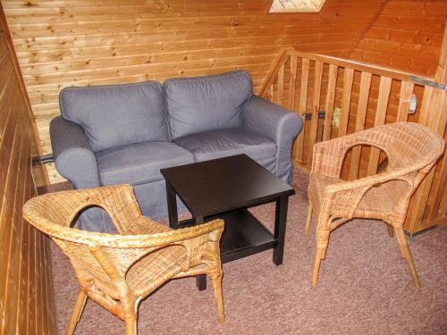 uma sala de estar com um sofá, cadeiras e uma mesa em Holiday Home Lenora I by Interhome em Lenora