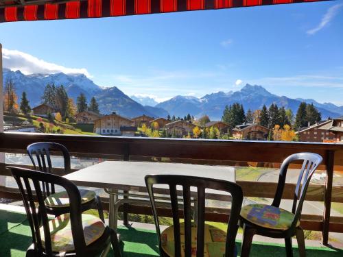 einen Tisch und Stühle auf einem Balkon mit Bergblick in der Unterkunft Apartment Diamant 39 by Interhome in Villars-sur-Ollon