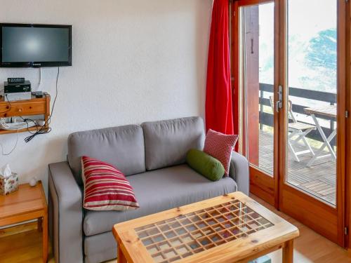 a living room with a couch and a table at Apartment Foret E3 by Interhome in Nendaz