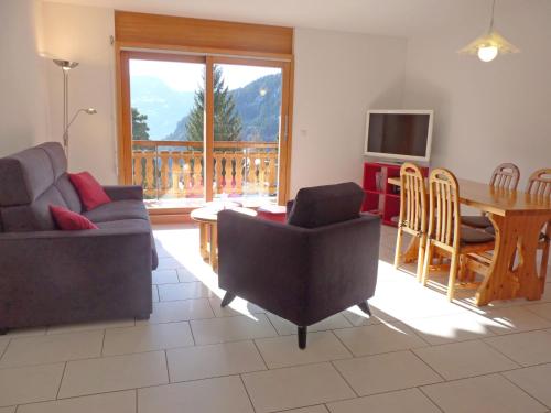 a living room with a couch and a table and a television at Apartment Ardévine 5 by Interhome in Ovronnaz