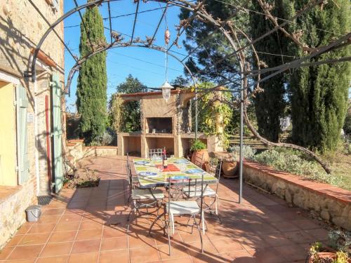 un patio avec une table et des chaises dans une cour dans l'établissement Holiday Home Mas Troumpill by Interhome, à Saint-Génis