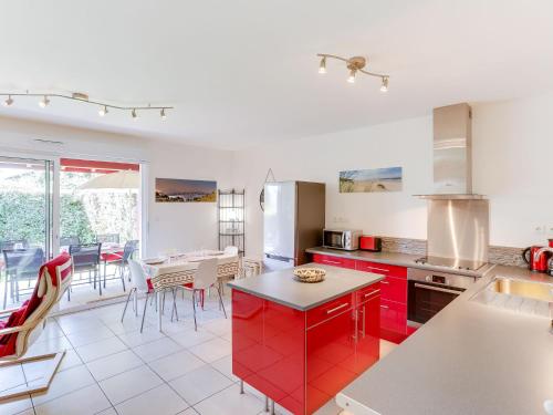 une cuisine avec des placards rouges et une table avec des chaises dans l'établissement Holiday Home Mendi Bixta by Interhome, à Amotz