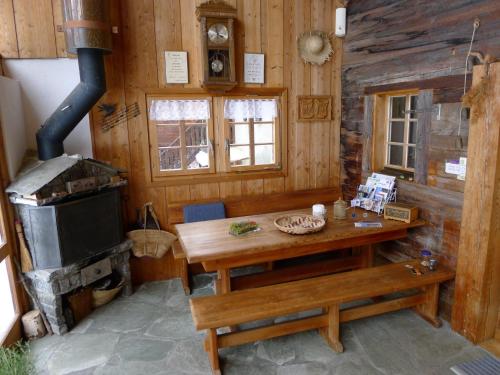ein Holzzimmer mit einem Tisch und einem Herd in der Unterkunft Apartment Poschthüs Biel-1 by Interhome in Ritzingen