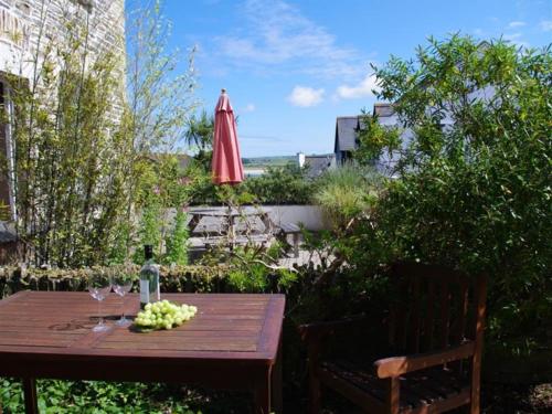 een houten tafel met wijnglazen en een rode paraplu bij Holiday Home Old School House by Interhome in Padstow