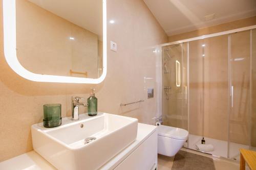 y baño con lavabo, aseo y espejo. en Newly Renovated Cozy Central Loft w/ AC by LovelyStay, en Oporto