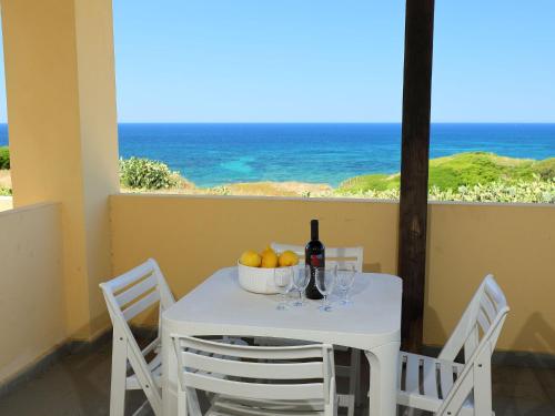 - une table avec un bol de fruits et une bouteille de vin dans l'établissement Apartment Ananas 4 D by Interhome, à Valledoria