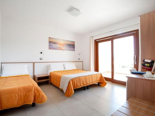 a hotel room with two beds and a window at Navicri B&B in Vieste