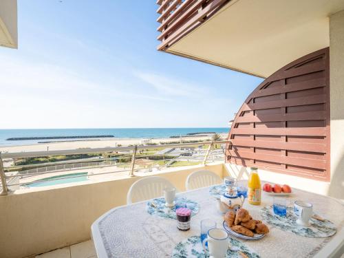 a table with food and a view of the beach at Apartment Le Sunset-Cap Sud-20 by Interhome in Cap d'Agde