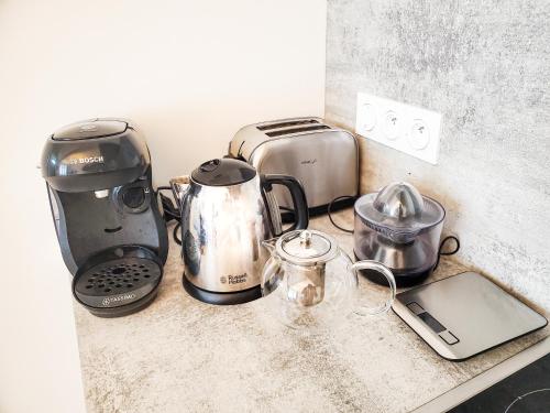 a counter top with a coffee maker and other appliances at APT bord de Mer, hypercentre Dinard, Parking prive in Dinard