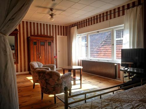 a living room with two chairs and a table and a window at Am Lindenplatz in Crinitz