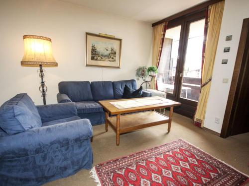 - un salon avec un canapé bleu et une table dans l'établissement Apartment Römer by Interhome, à Bad Hofgastein
