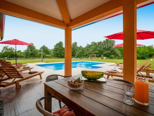 a patio with a table and chairs and a pool at Holiday Home Villa Frankovići by Interhome in Brajkovići
