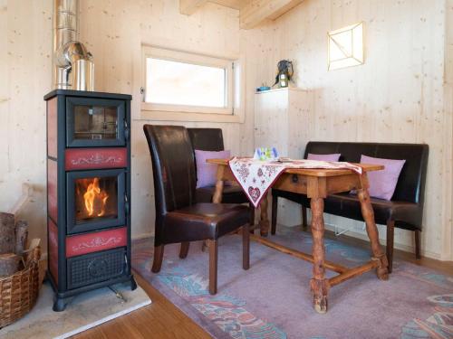 Zimmer mit einem Holzofen, einem Tisch und Stühlen in der Unterkunft Chalet Shakti by Interhome in Reith bei Seefeld