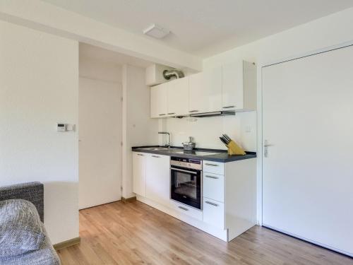 une cuisine avec des armoires blanches et une cuisinière dans l'établissement Apartment Santa Monica 1 by Interhome, au Cap d'Agde