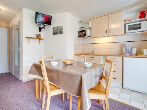 Apartment Ski Soleil 1 by Interhome في ليه مينوير: مطبخ مع طاولة وكراسي في غرفة