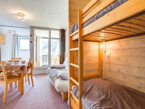 Apartment Ski Soleil 1 by Interhome في ليه مينوير: غرفة نوم مع سرير بطابقين وغرفة طعام مع طاولة