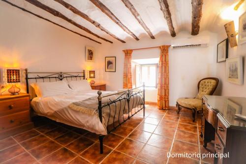 1 dormitorio con 1 cama y 1 silla en Calle Horno, en Castril