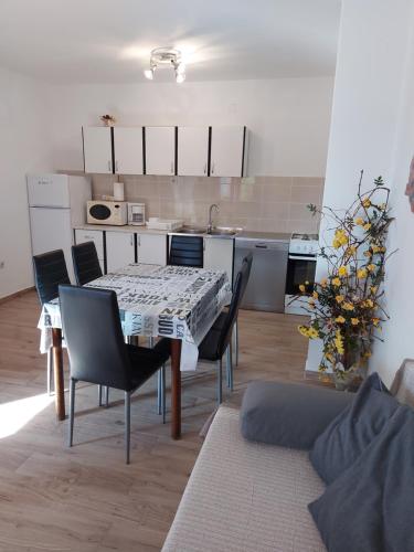 a table and chairs in a living room with a kitchen at Apartment Valeria in Lopar