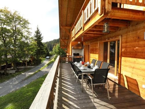 a wooden deck with a table and chairs on a house at Chalet Chalet Maurice by Interhome in Chesières