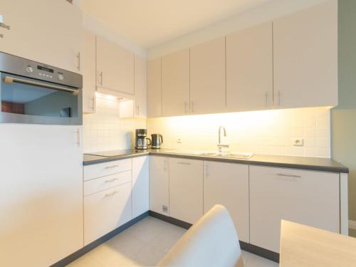eine weiße Küche mit weißen Schränken und einem Waschbecken in der Unterkunft Apartment Seaside 4-02 by Interhome in Bredene
