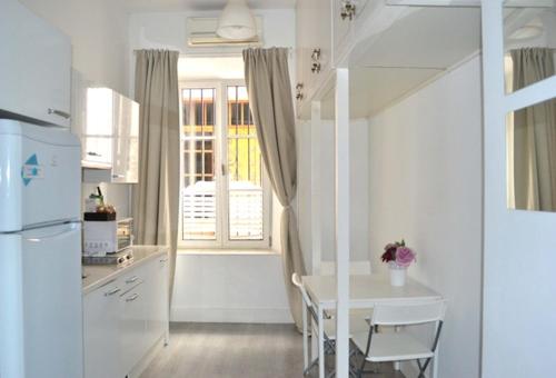 a kitchen with white cabinets and white appliances at Casas y Patios de Sevilla in Seville